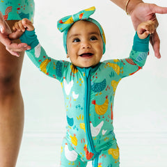 Baby in Cozy Coop Zippy pajamas with matching Luxe Bow Headband.