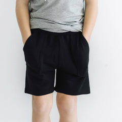 cropped image of a child wearing black bamboo viscose shorts from play by little sleepies