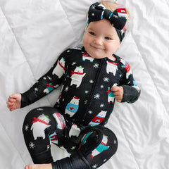 Child wearing Polar Bear Pals zippy pajamas with matching Luxe Bow Headband
