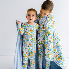 Children in Jungle Safari printed pajamas with matching cloud blanket