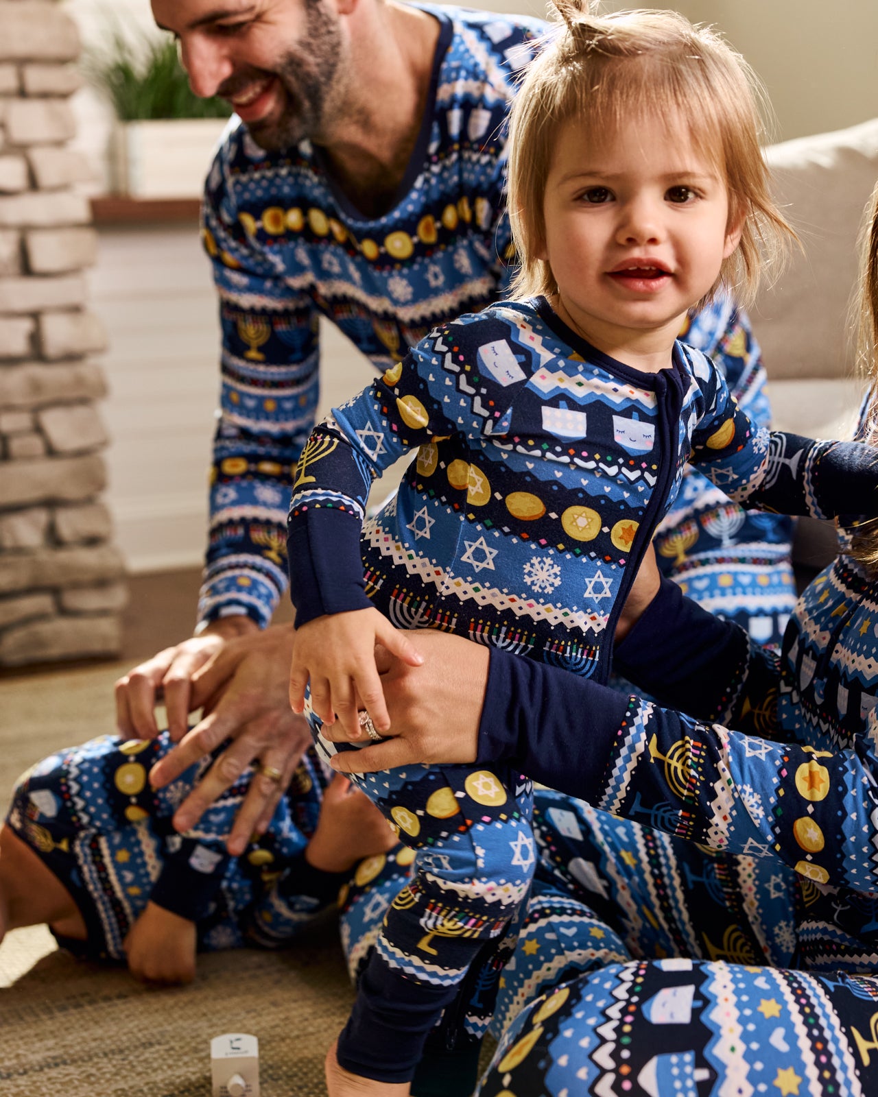 Girl wearing the Hanukkah Fair Isle Zippy in a living room