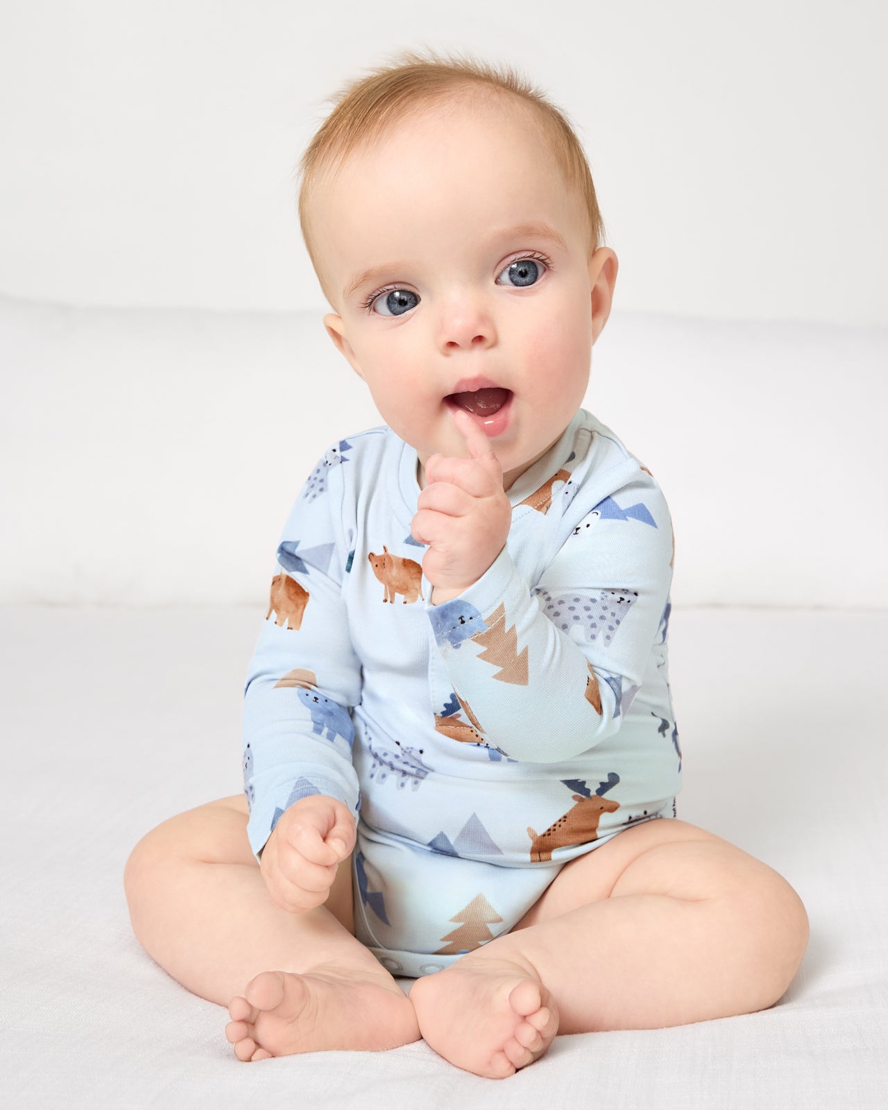 Sitting baby wearing the Alpine Explorers Henley Bodysuit