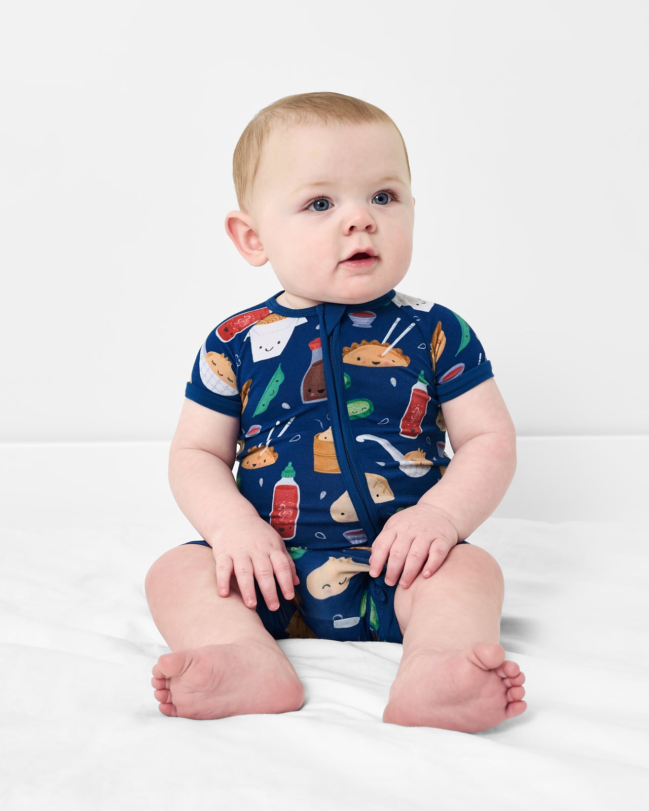 Sitting baby wearing the Bao Buddies Shorty Zippy