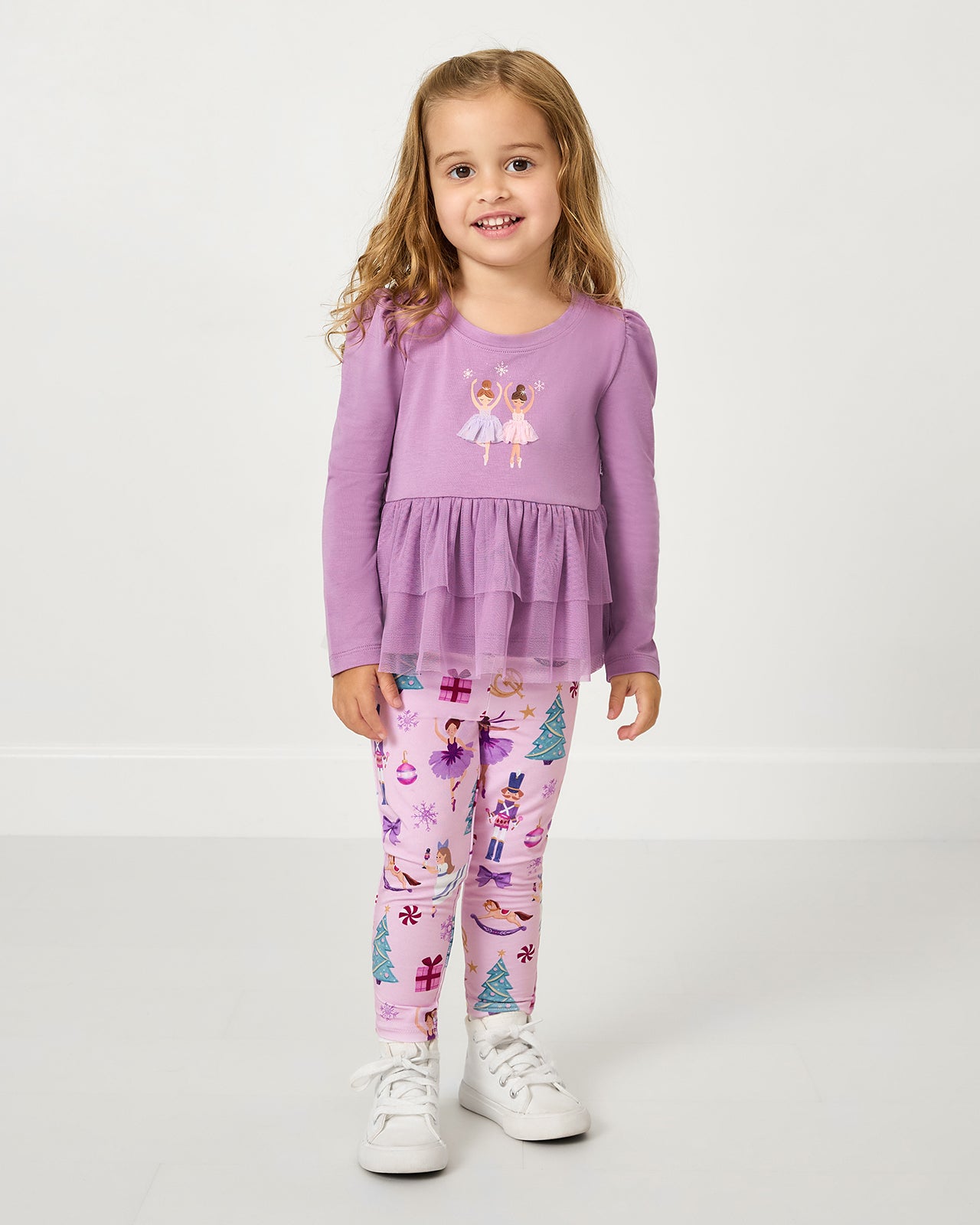 Girl wearing the Nutcracker Ballet Legging with a purple peplum top