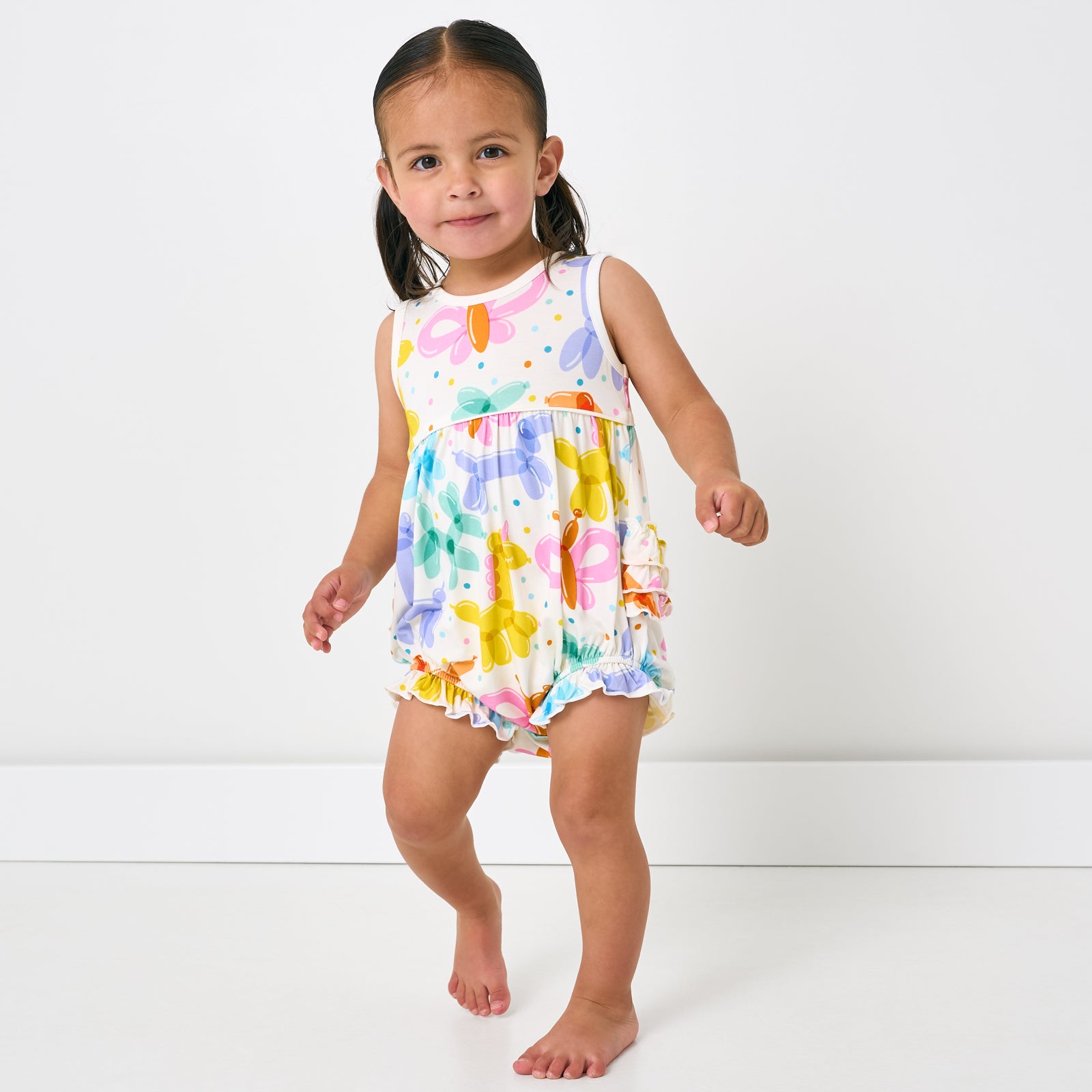 Standing child wearing the Balloon Bash Bubble Romper