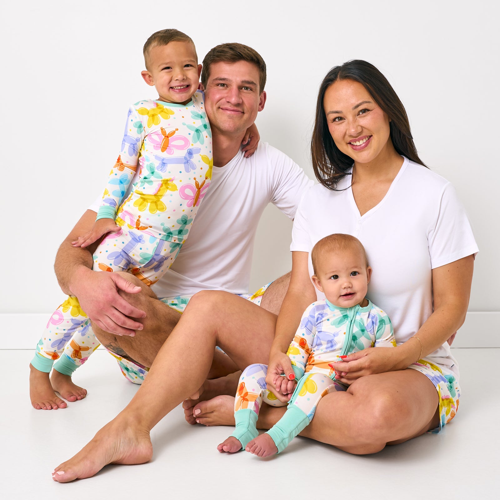 Family of four wearing matching Balloon Bash bamboo pajamas