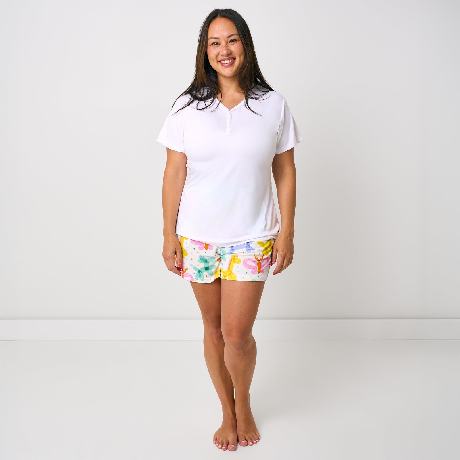 Standing woman wearing the Balloon Bash Women's Pajama Shorts with a white pj top