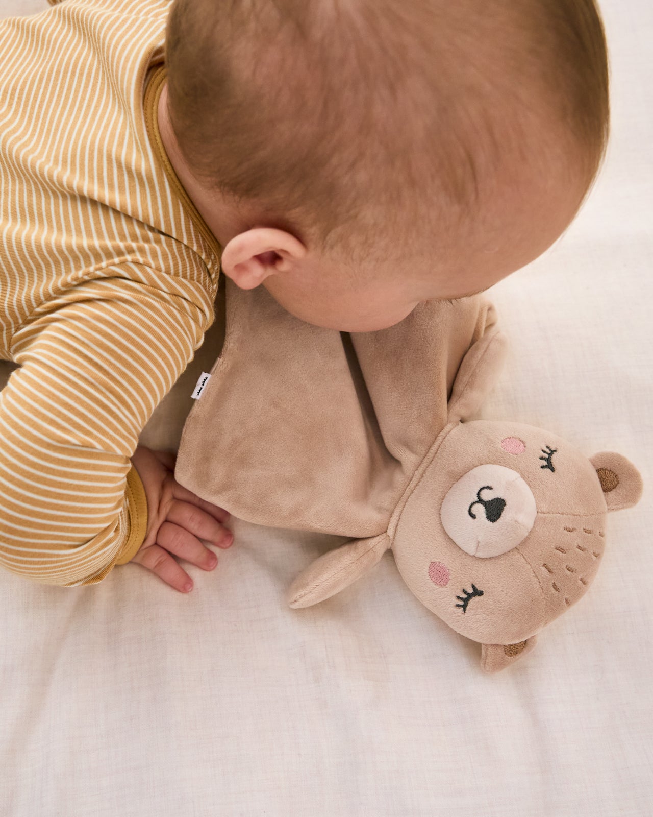 Baby laying with the Bear Sleepyhead Lovey