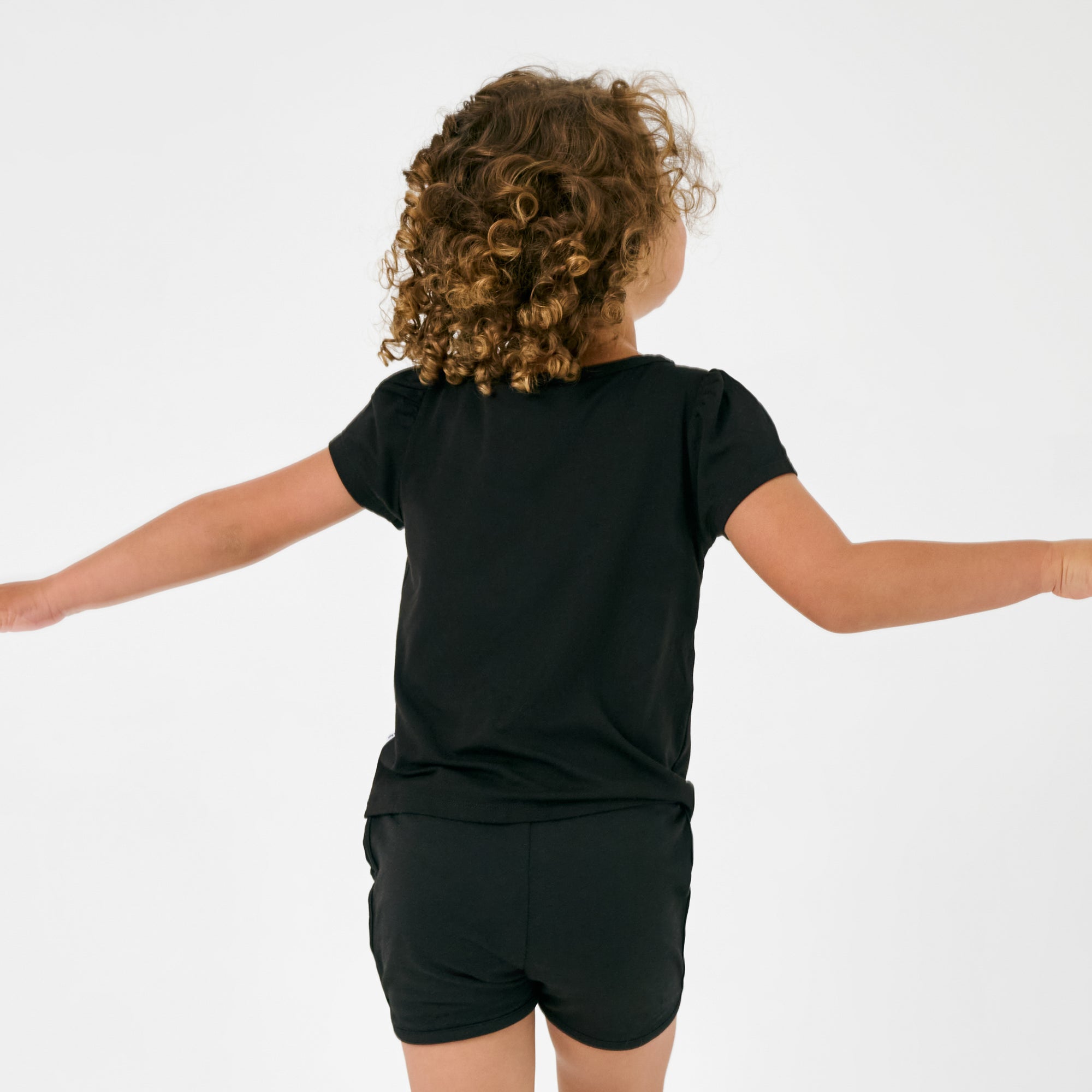 Back view of child wearing the Black Dolphin Shorts