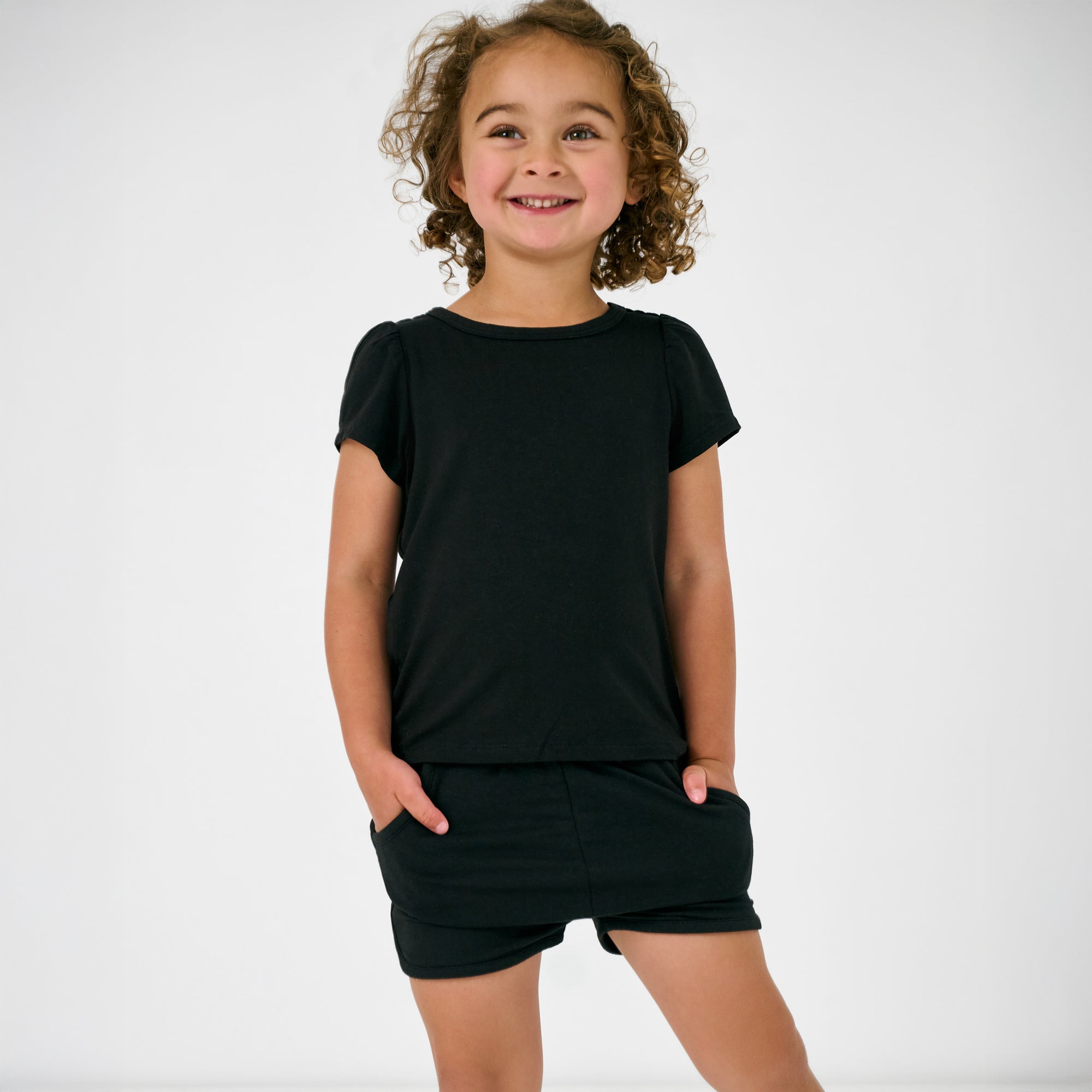 Standing child wearing the Black Dolphin Shorts