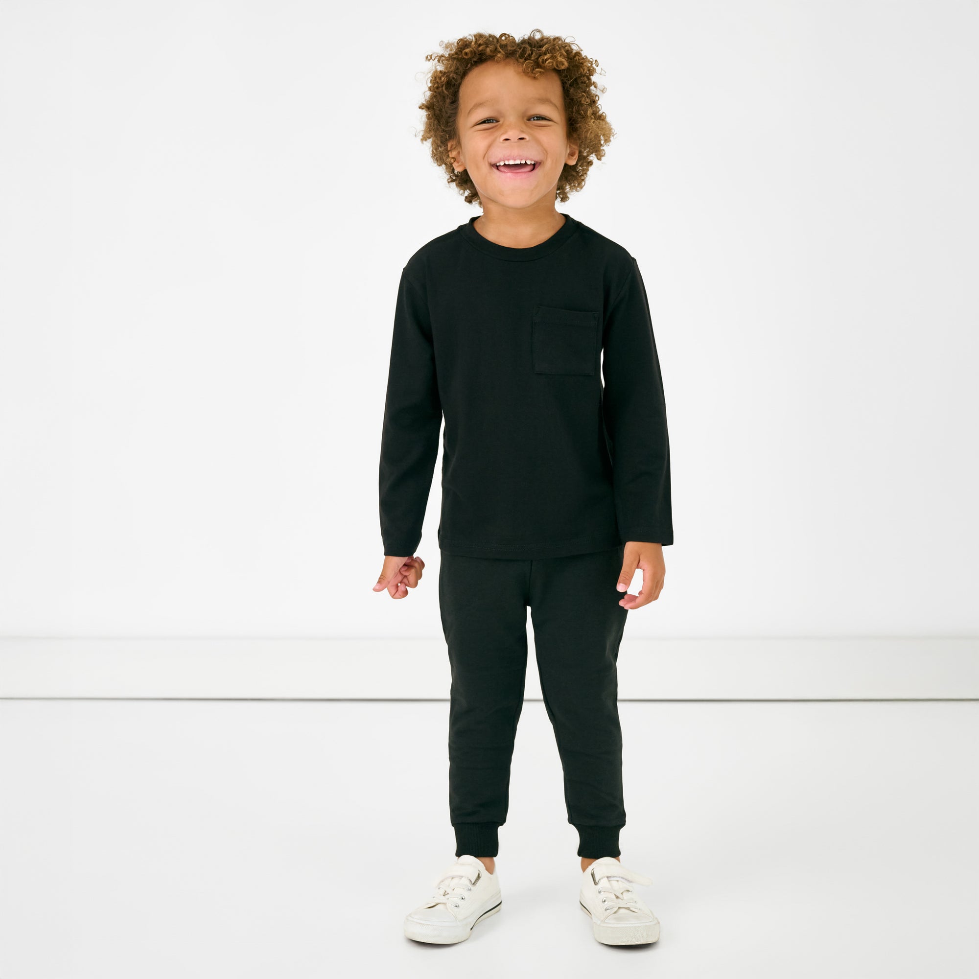 Standing child wearing the Black Jogger with a matching long sleeve tee