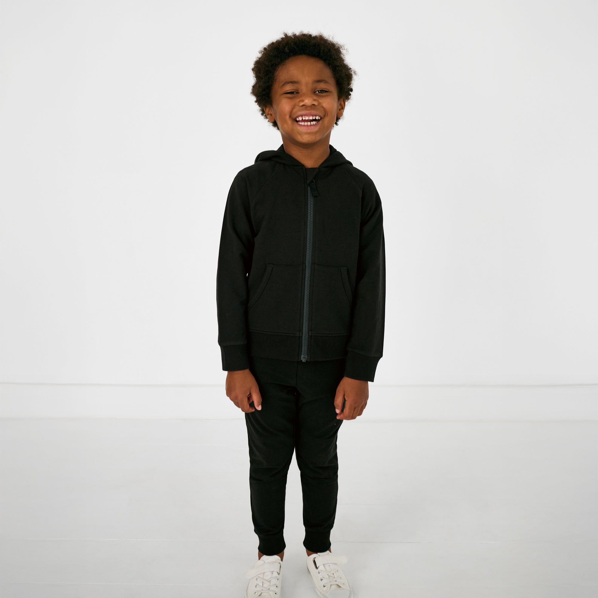 Standing child wearing the Black Zip Hoodie and joggers