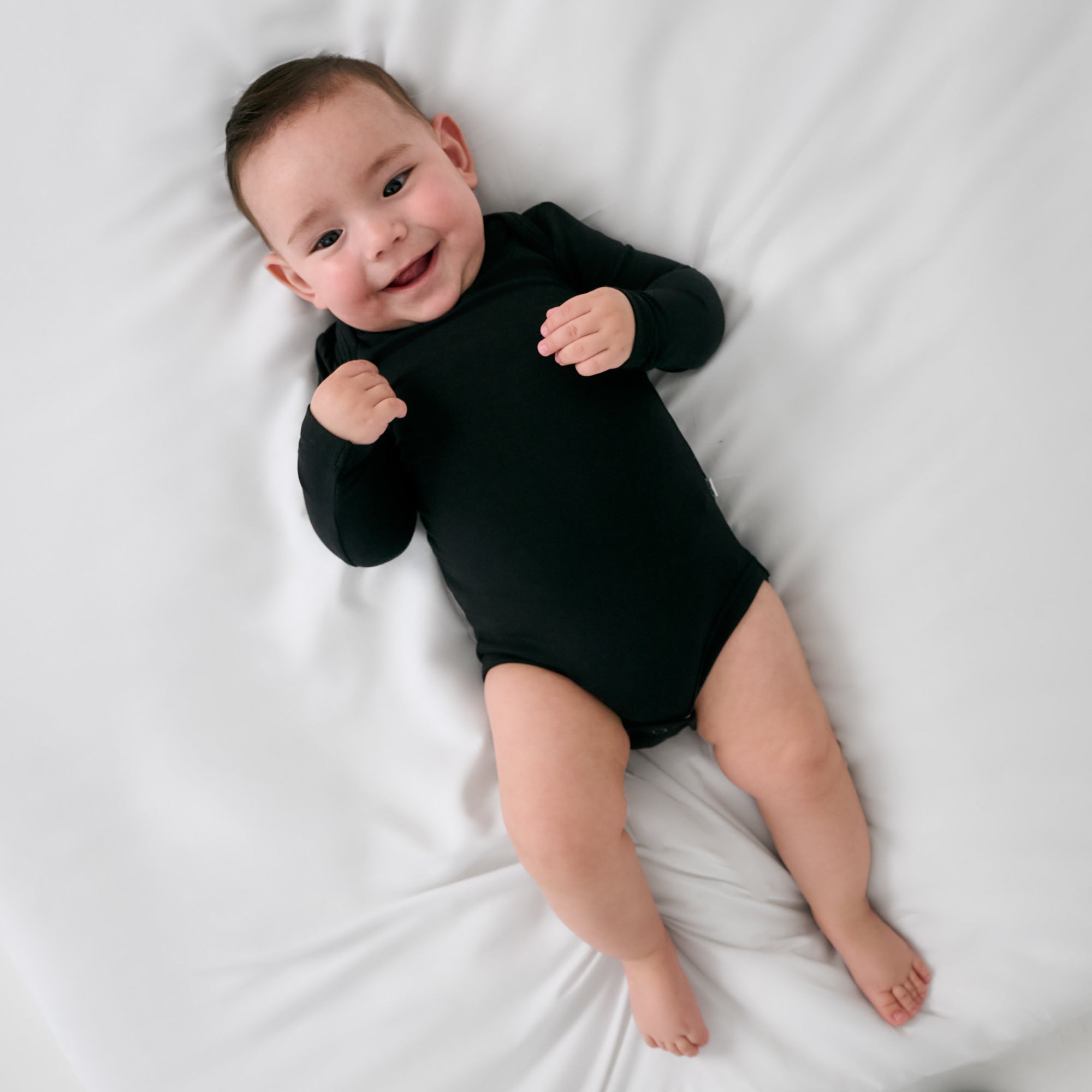 Alternate aerial view of baby wearing the Black Long Sleeve Bodysuit