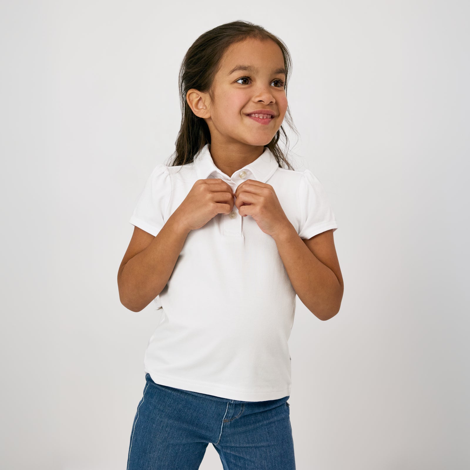 Child buttoning the collar on the Bright White Puff Sleeve Polo