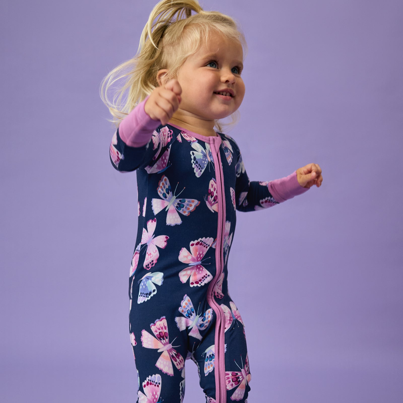 Toddler wearing the Royal Butterflies Zippy on a purple background