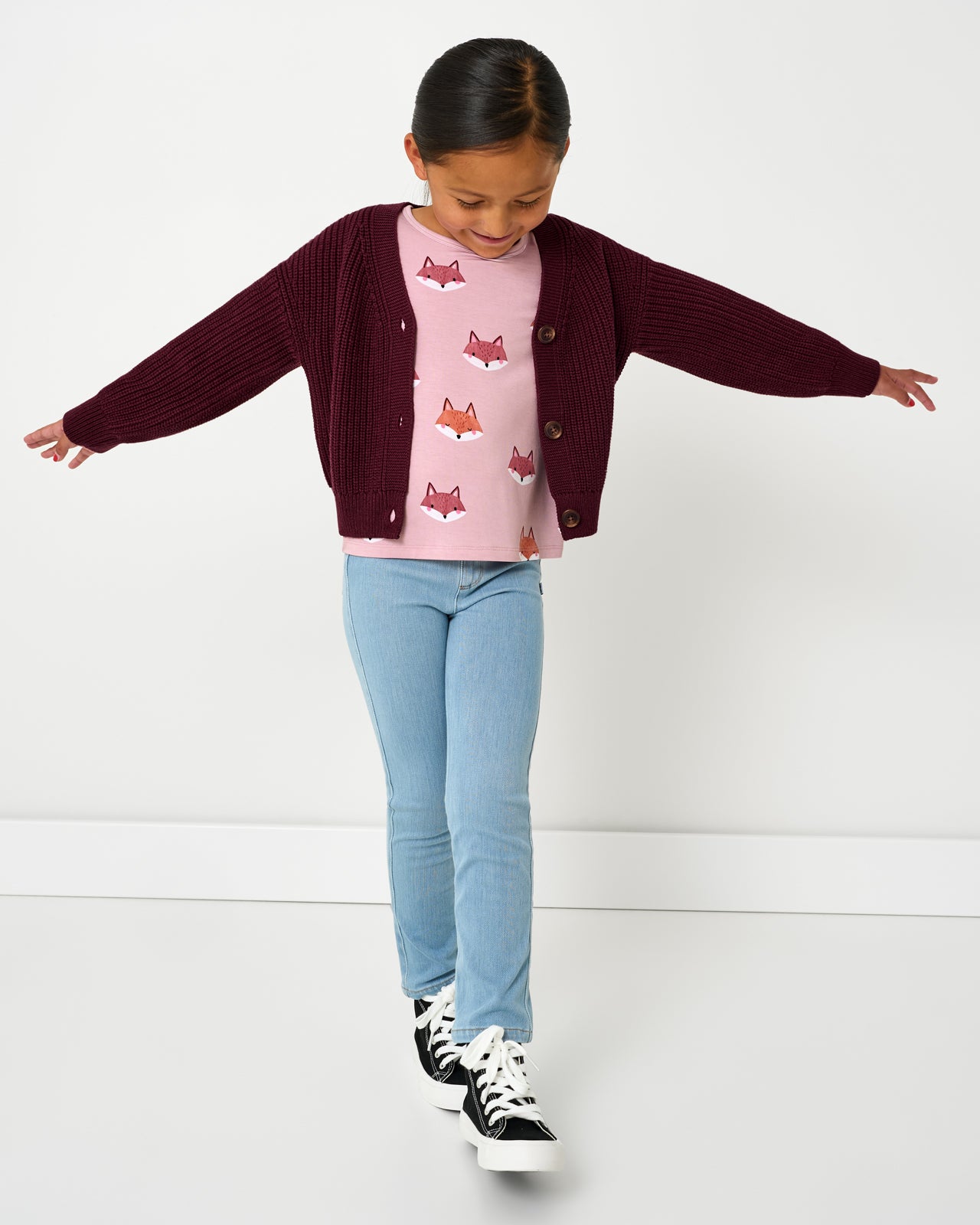 Girl wearing the Classic Burgundy Cropped Sweater with denim pants