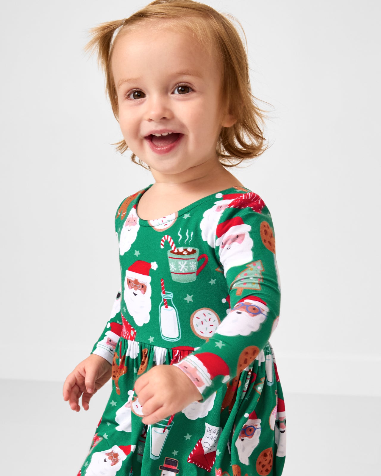 Close up of toddler wearing the Cookies for Santa Bow Back Skater Dress with Bodysuit