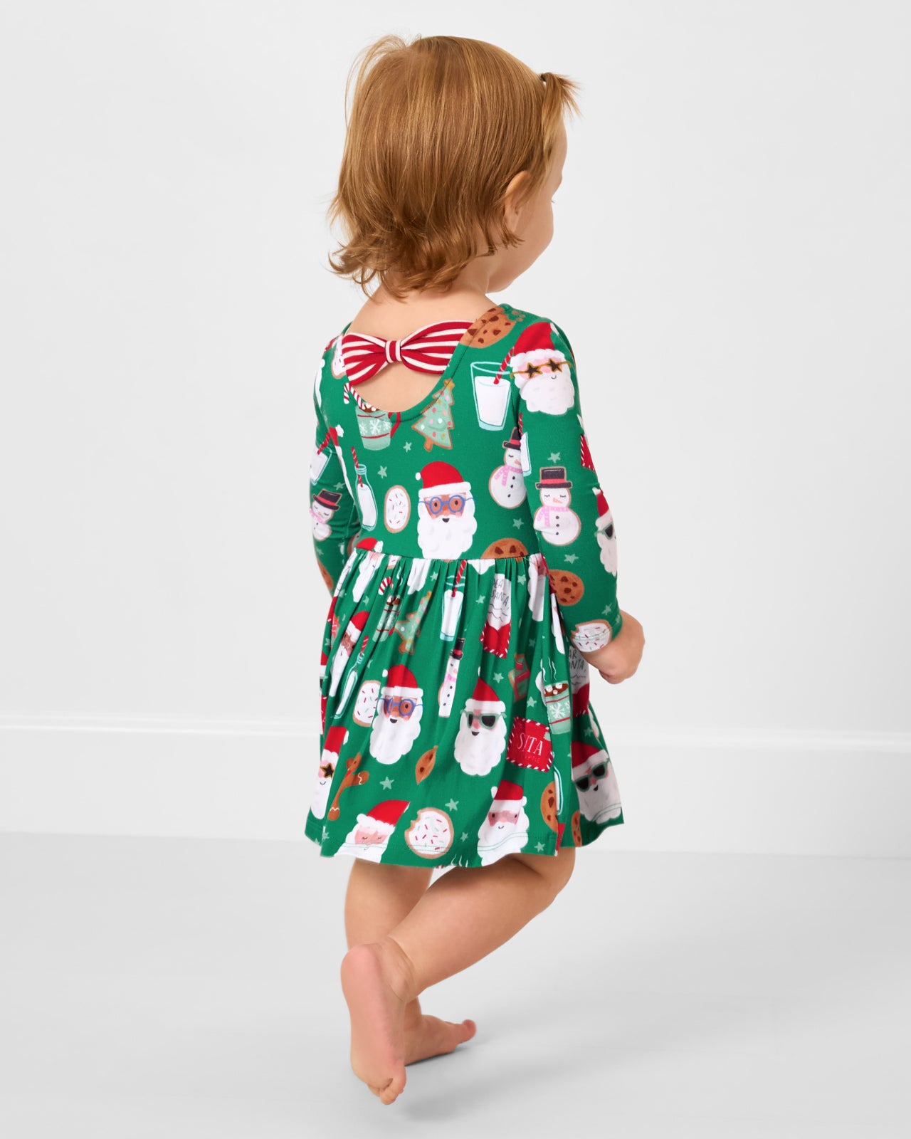 Back view of toddler wearing the Cookies for Santa Bow Back Skater Dress with Bodysuit
