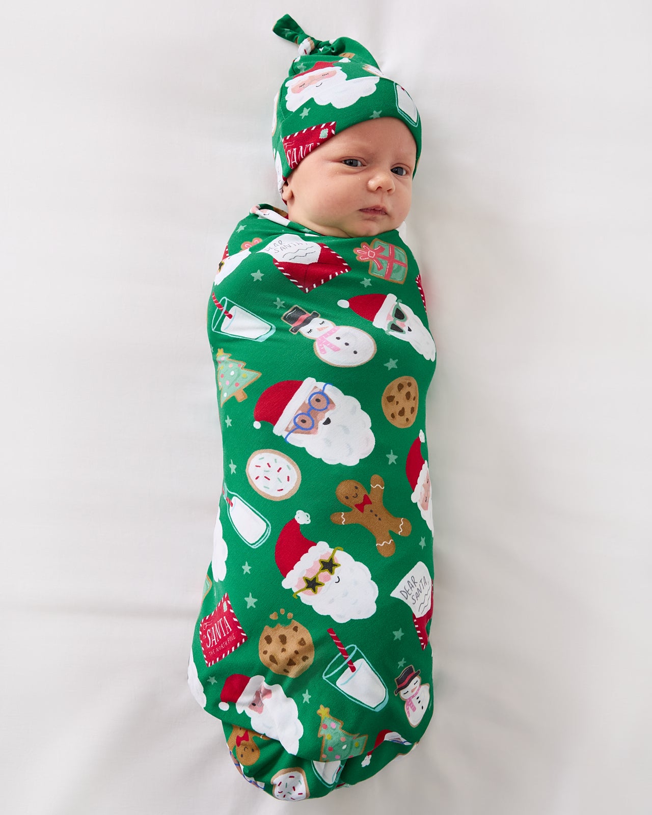 Aerial view of baby wearing the Cookies for Santa Swaddle & Hat Set