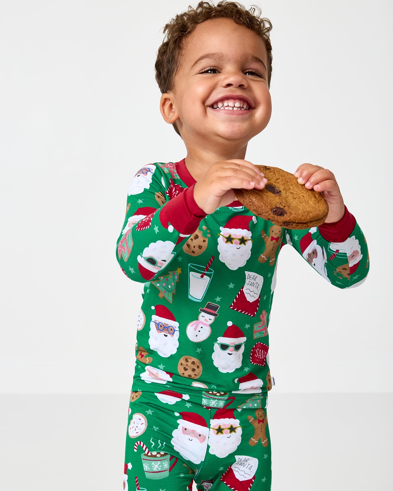 Child holding a cookies wearing the Cookies for Santa Two-Piece Pajama Set