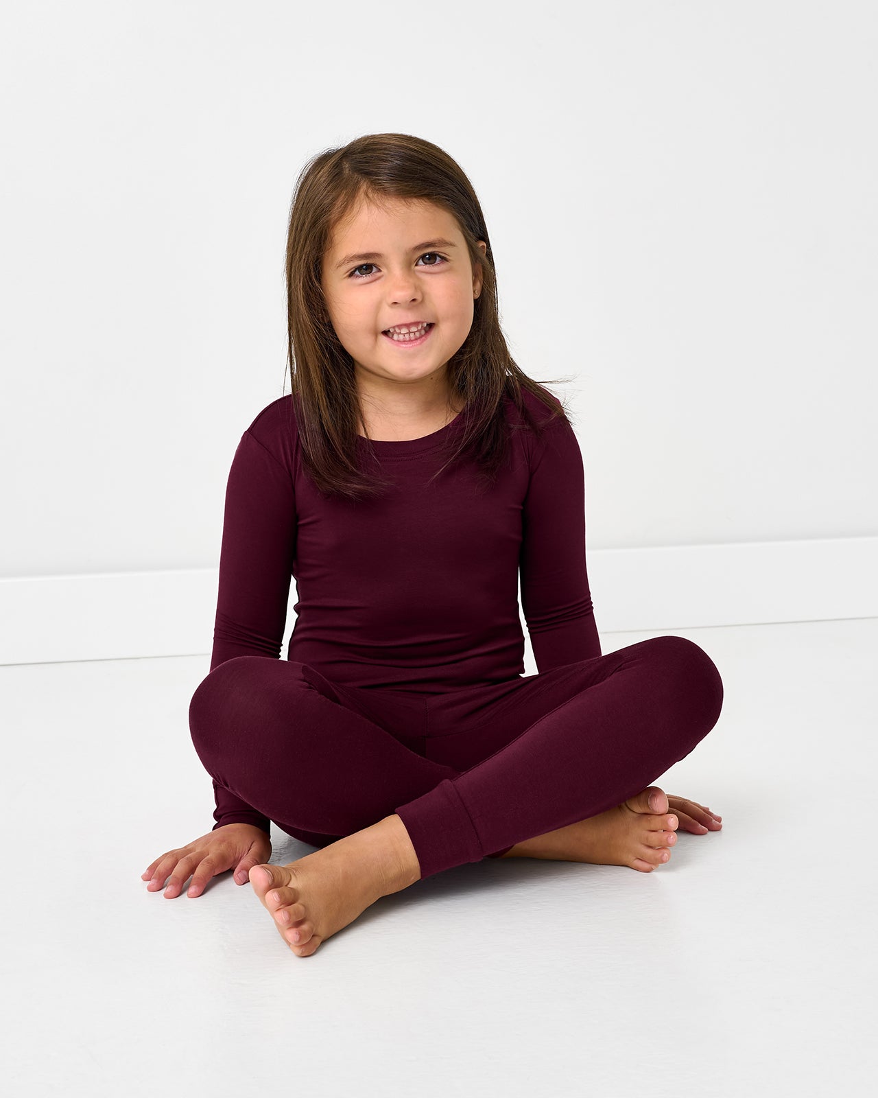 Sitting girl wearing the Classic Burgundy Two-Piece Pajama Set