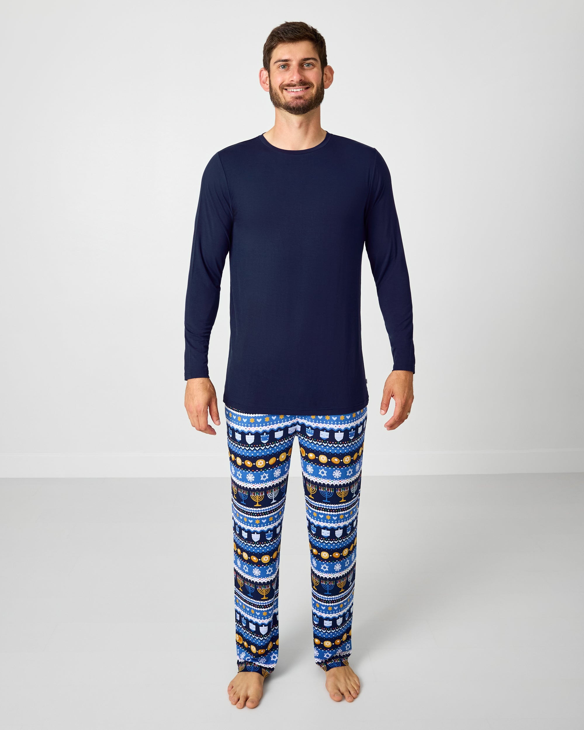 Man wearing the Classic Navy Men's Long Sleeve Pajama Top with Hanukkah Fair Isle pants