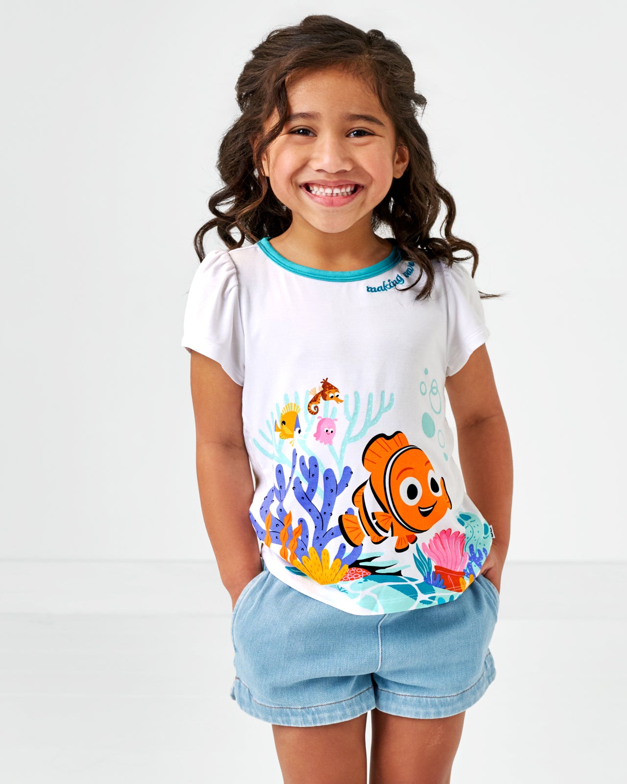 Standing child wearing the Disney Nemo Puff Sleeve Tee and light blue denim shorts