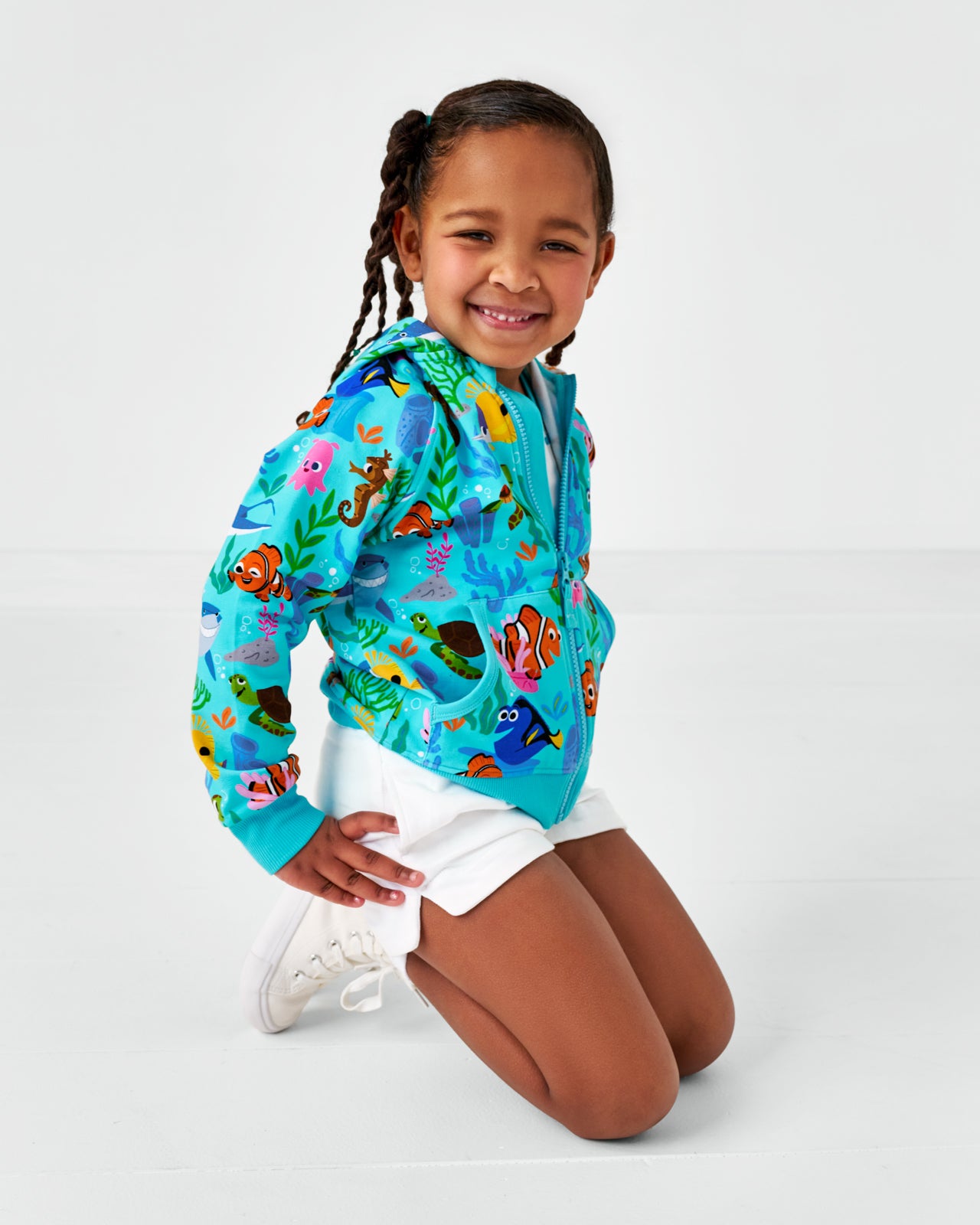 Posing child wearing the Pixar Nemo's Reef Zip Up Hoodie