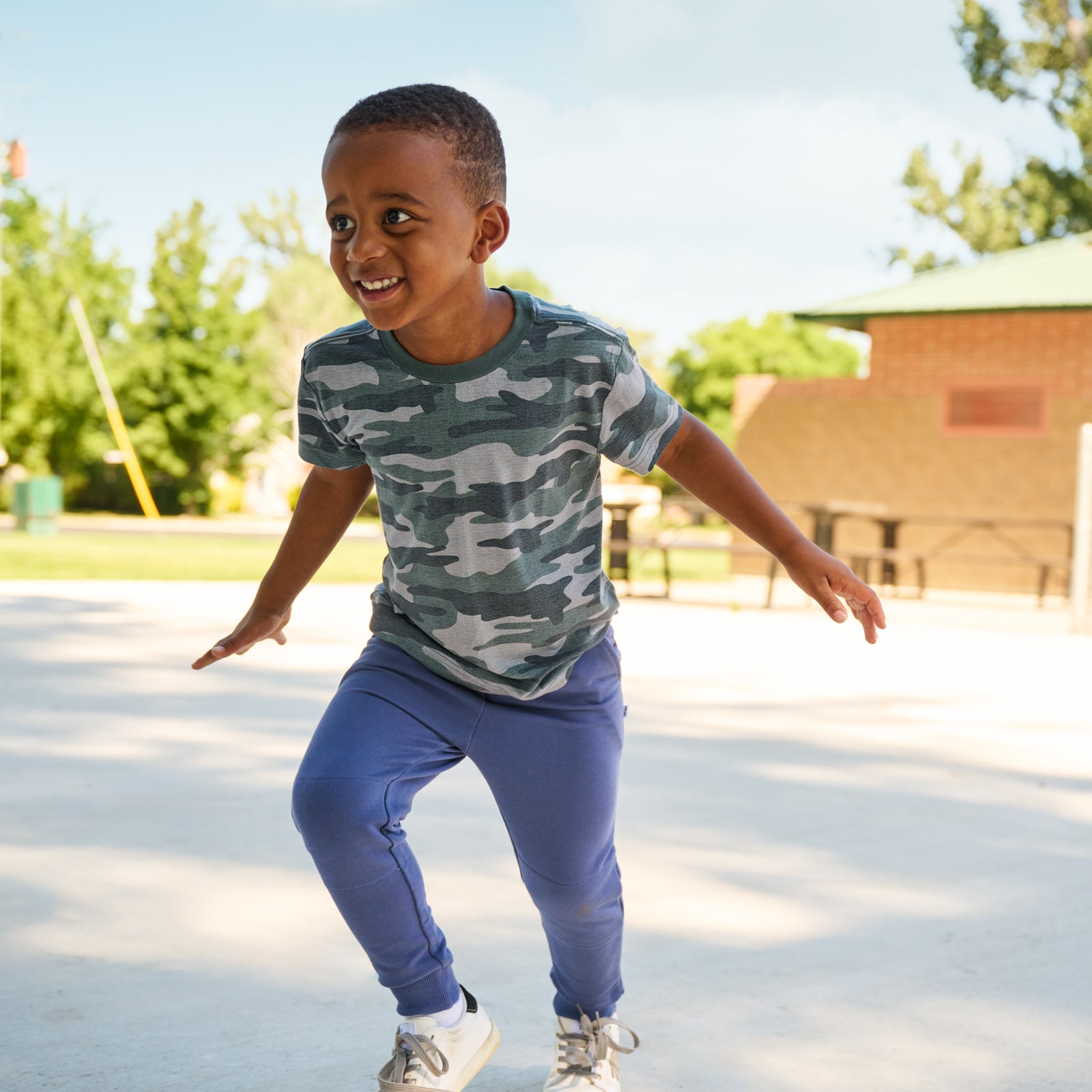 boy wearing vintage navy joggers and camo tee shirt
