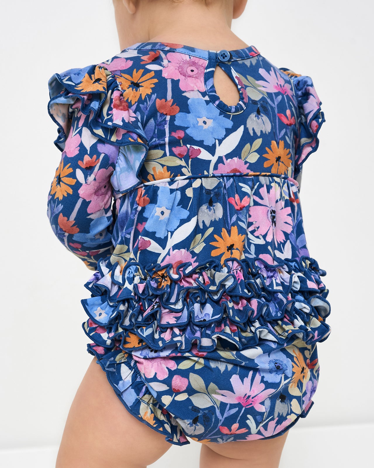 Back view of baby wearing the Dusk Blooms Bubble Romper