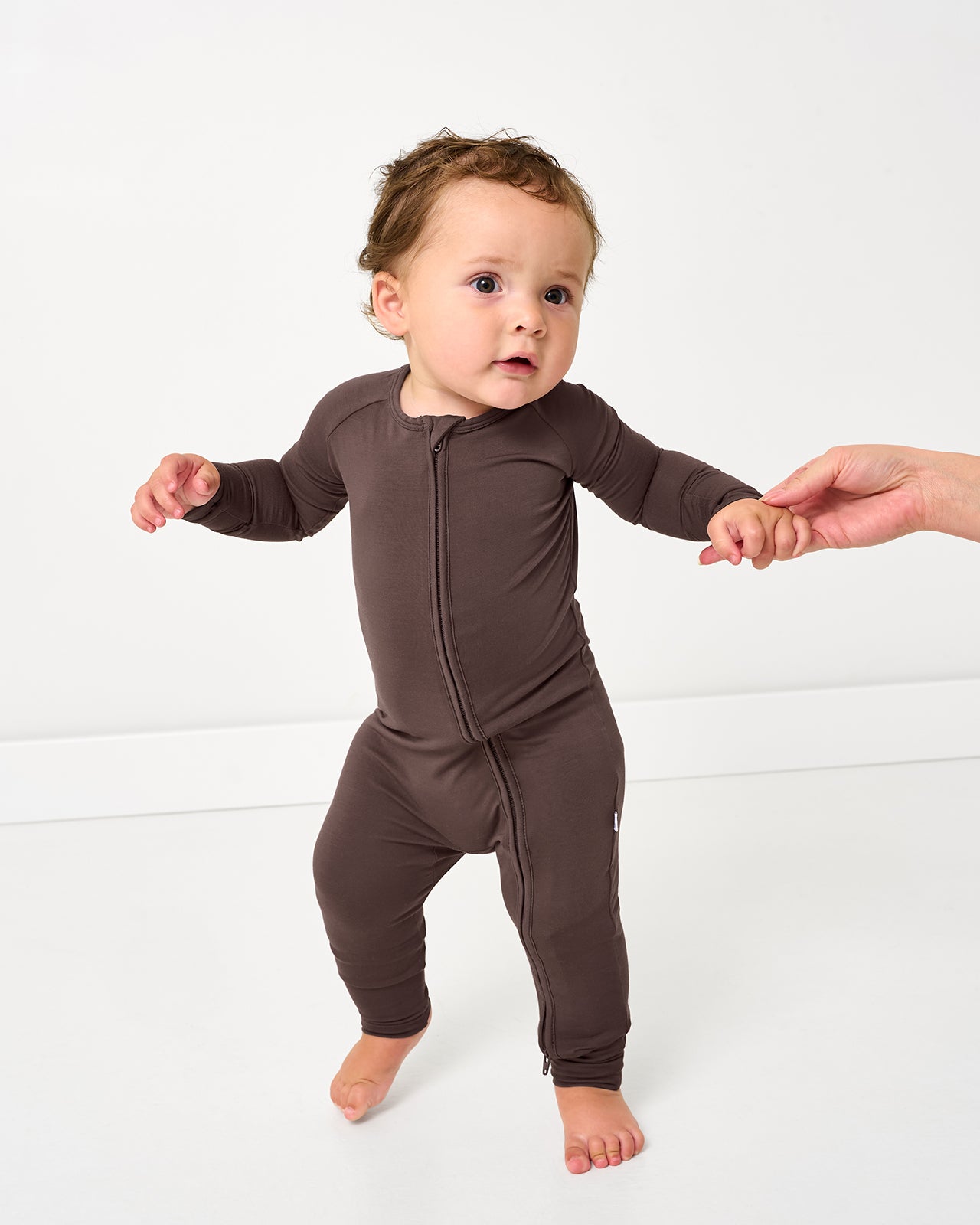 Walking baby wearing the Dark Chocolate Zippy