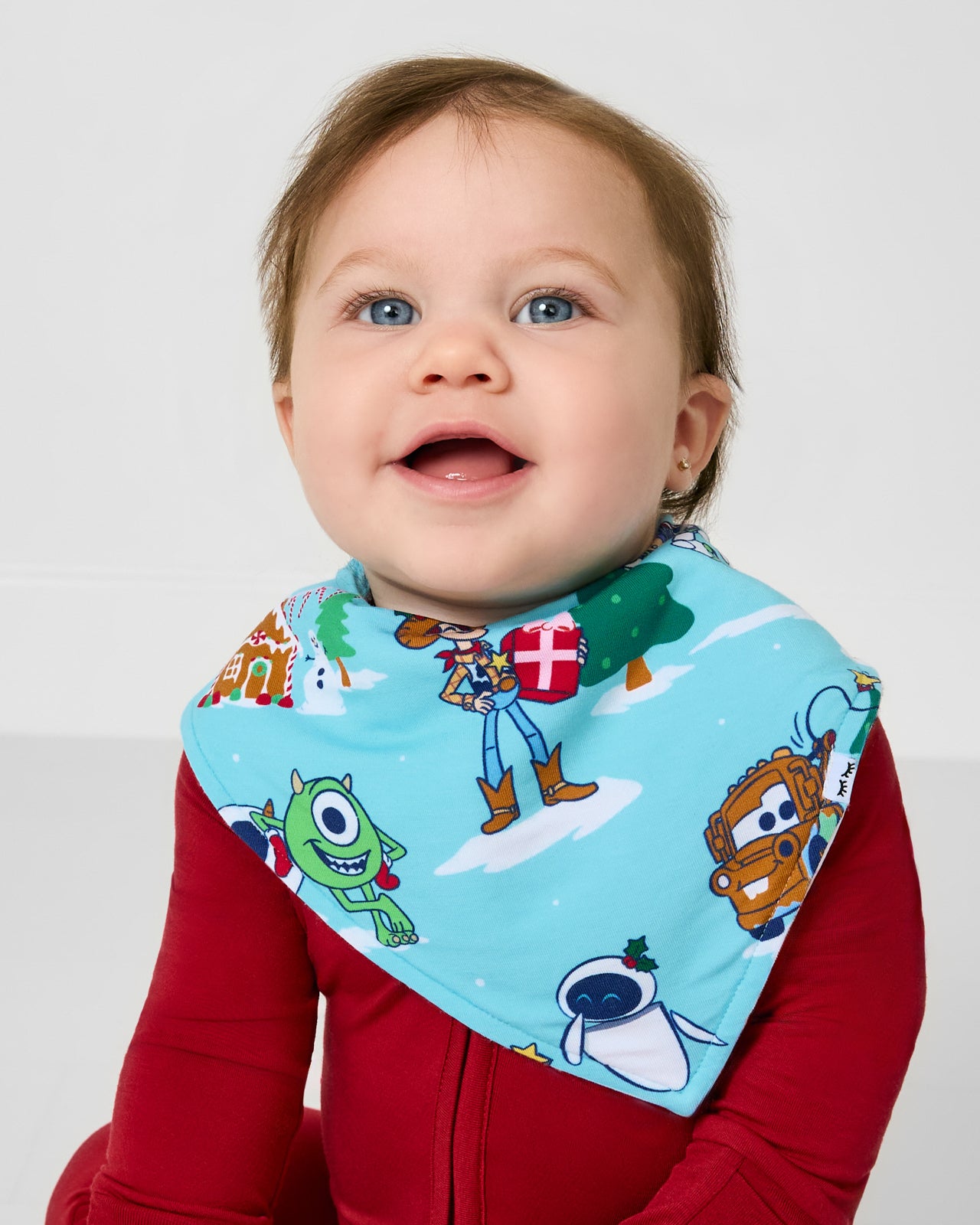 Baby wearing the Disney & Pixar Christmas Village Bandana Bib