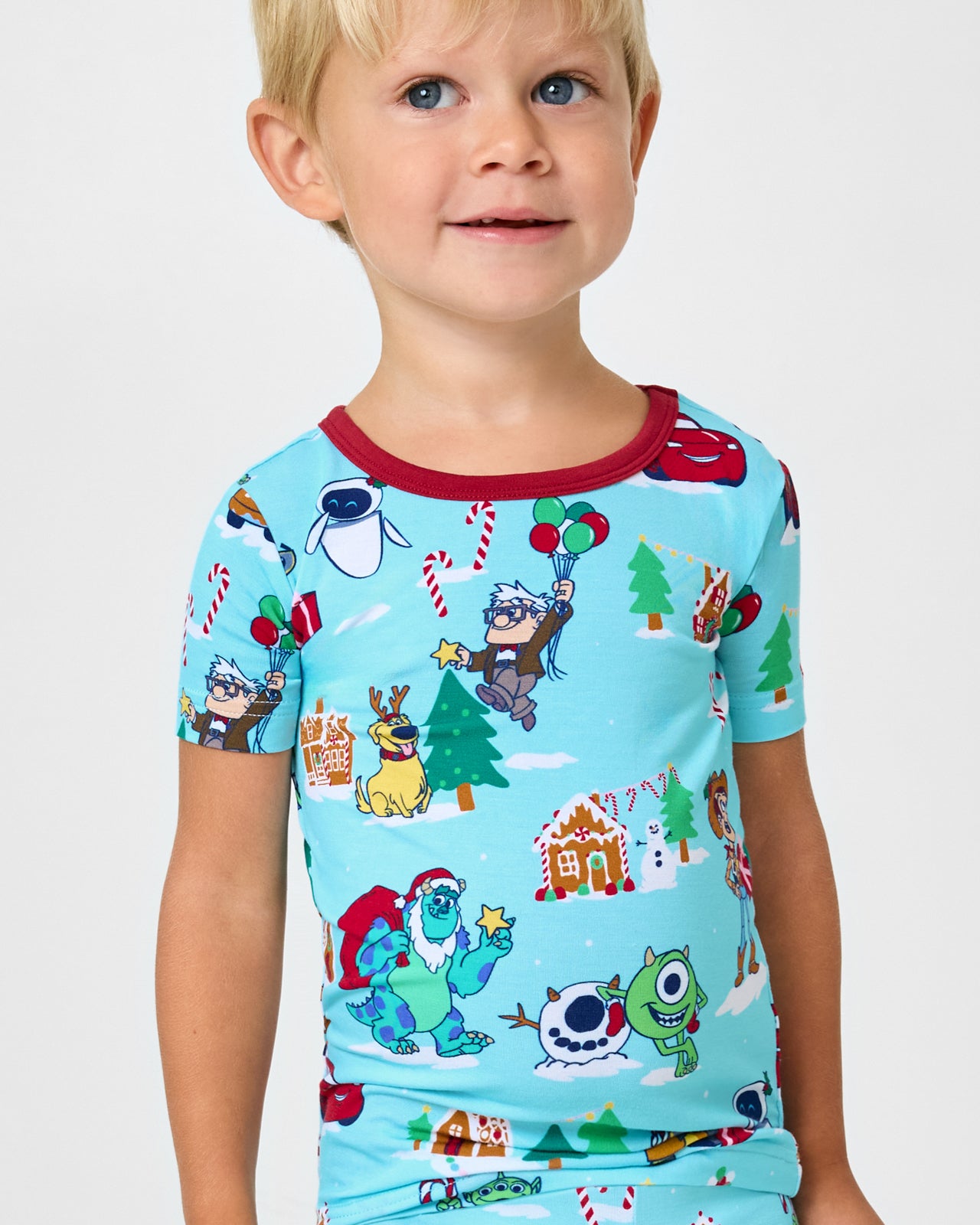 Close up of boy wearing the Disney & Pixar Christmas Village Two-Piece Short Sleeve & Shorts Pajama Set