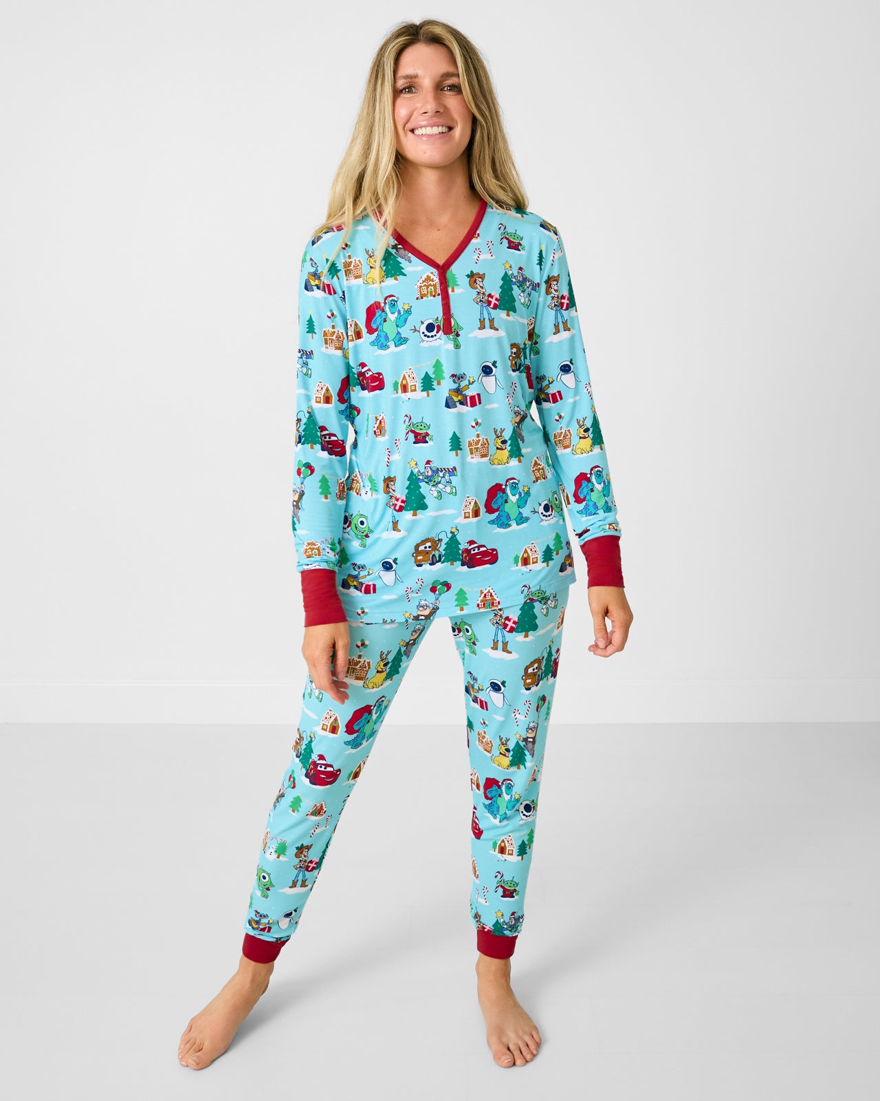 Woman wearing the Disney & Pixar Christmas Village Women's Pajama Pants with a matching pajama top