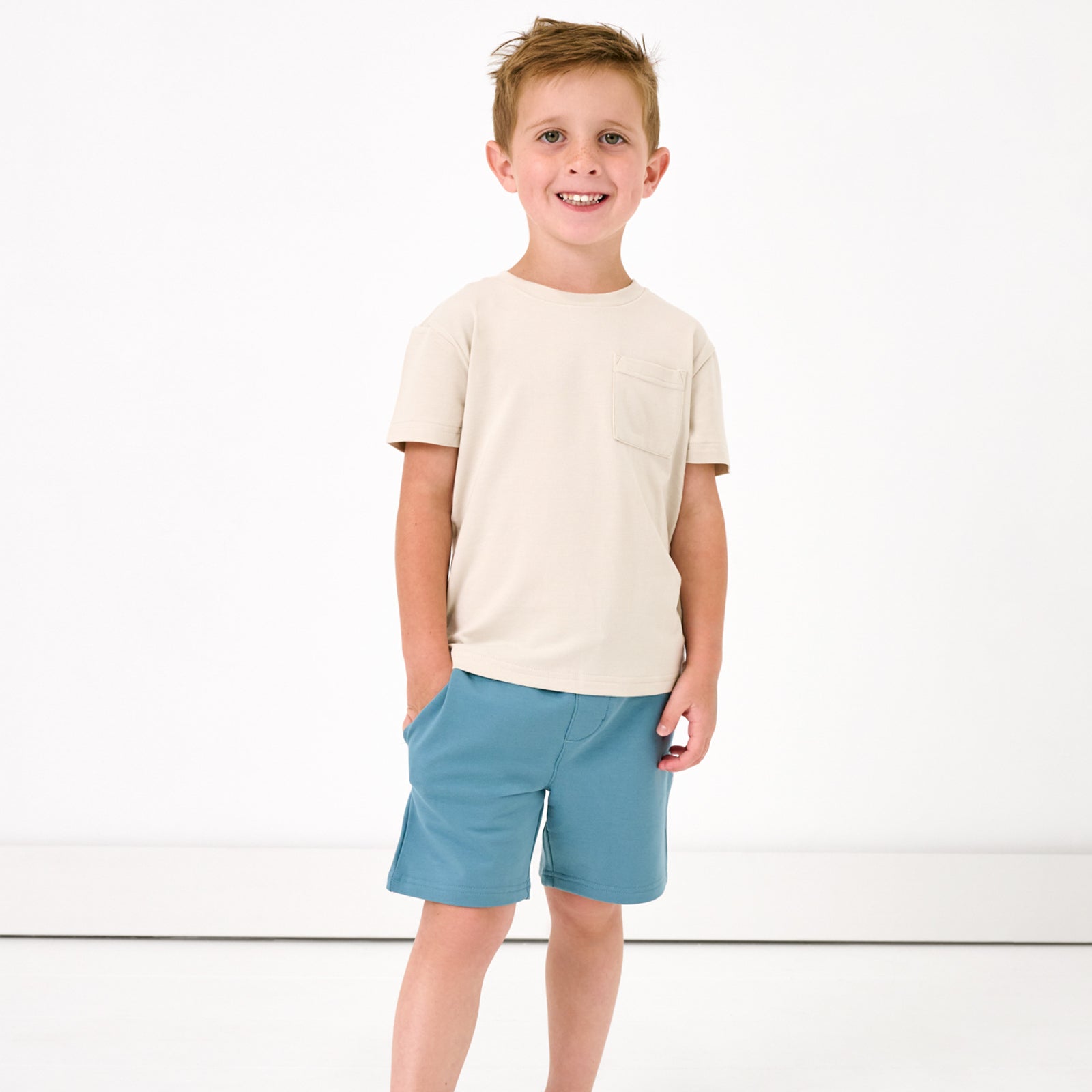 Alternate of standing child wearing the Pale Pearl Relaxed Pocket Tee with dusk blue shorts