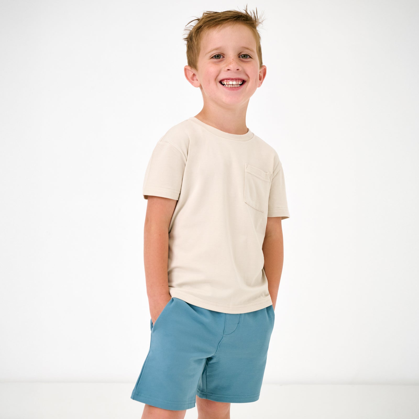 Standing child wearing the Pale Pearl Relaxed Pocket Tee