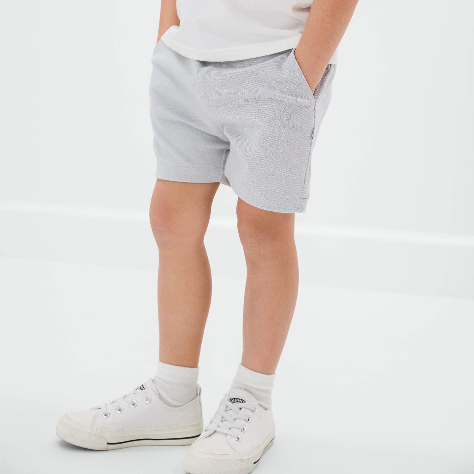 Close up of child wearing the Earl Gray chino shorts with sneakers