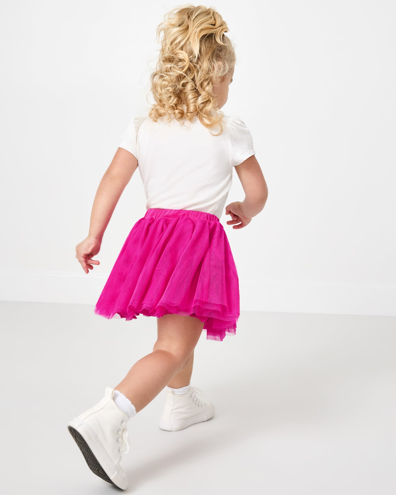 Back view of running child wearing the Electric Fuchsia Tutu Skirt with a white top