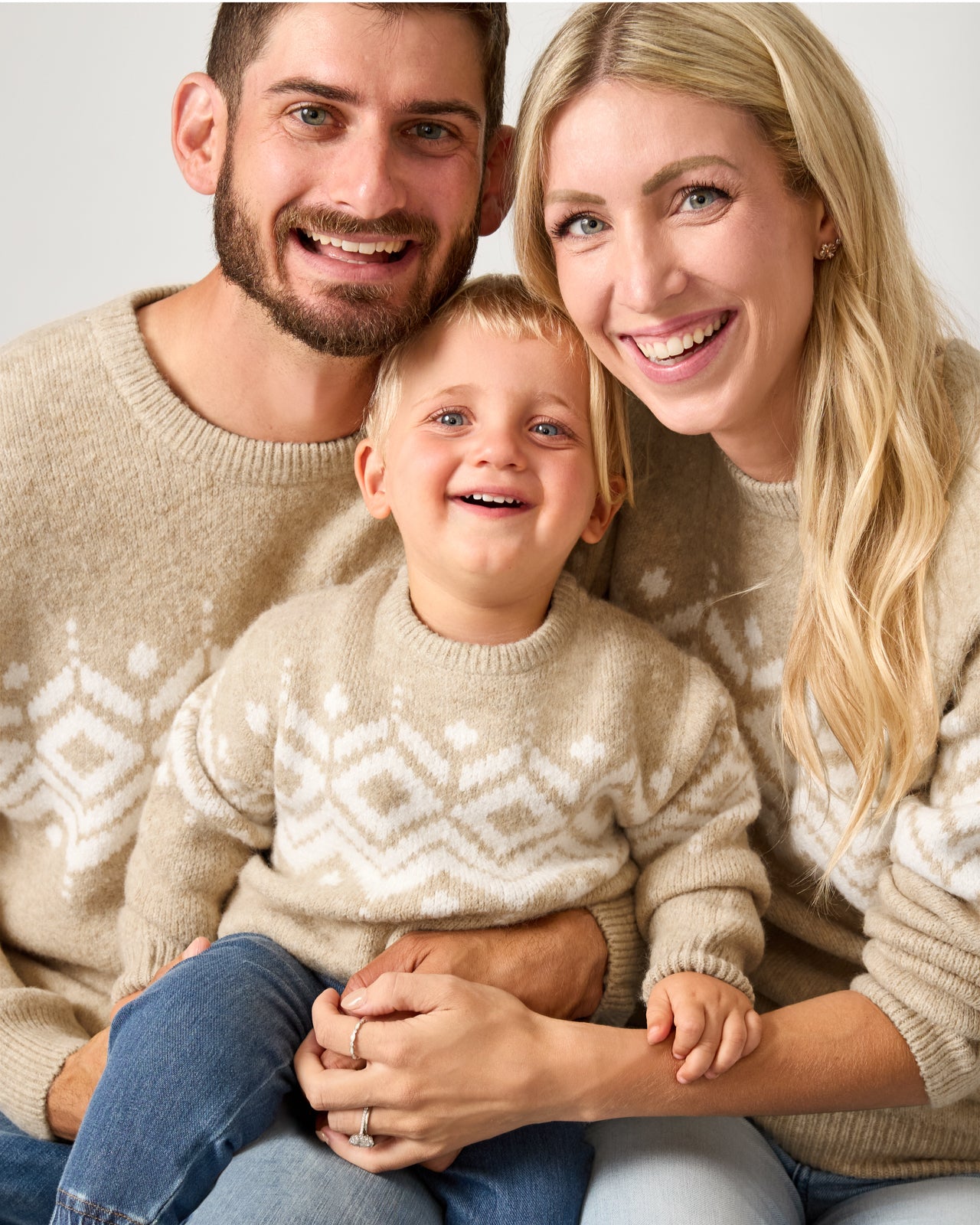 Family of three wearing matching Neutral Fair Isle Sweaters