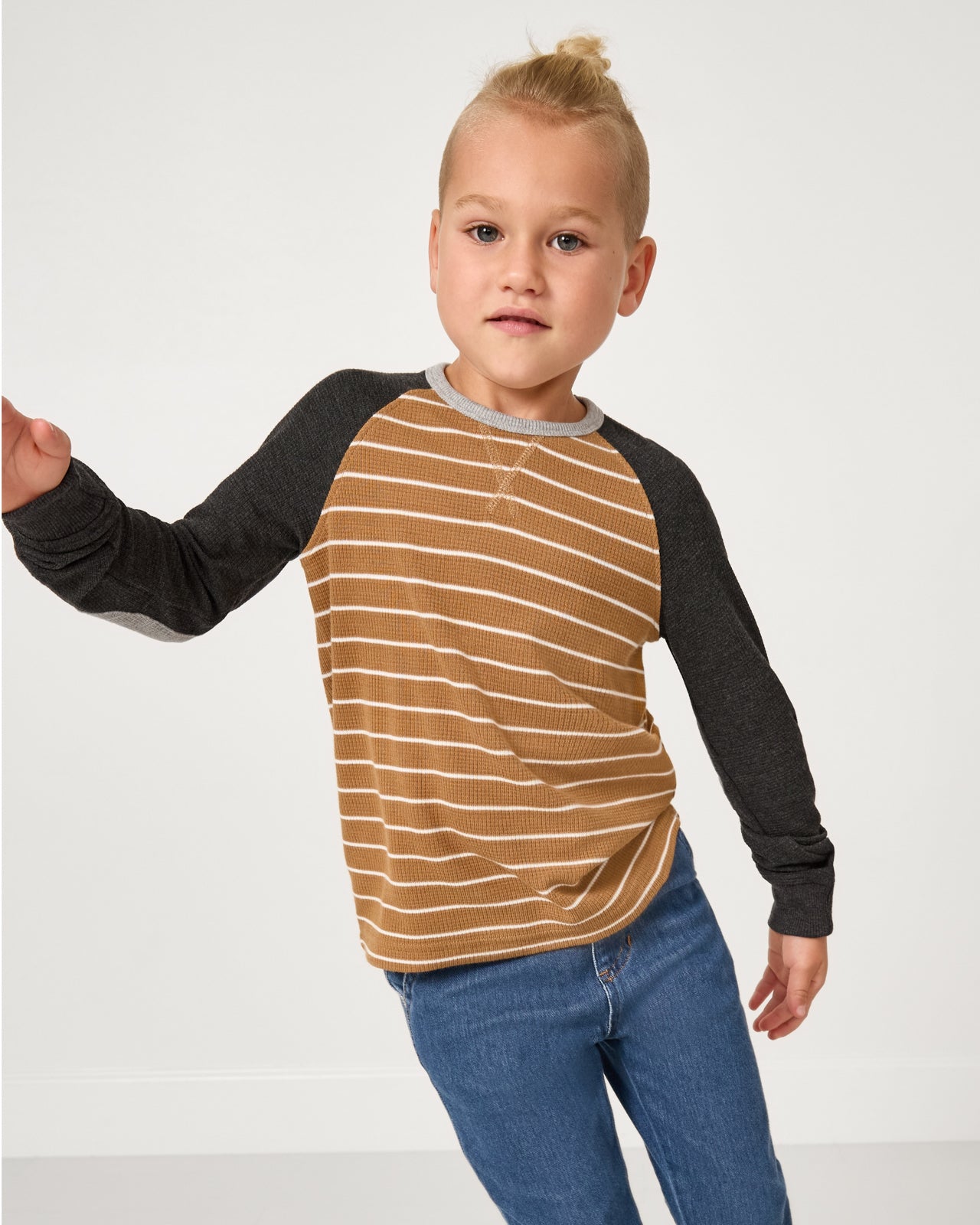 Child in motion wearing the Cider Stripe Waffle Raglan Tee