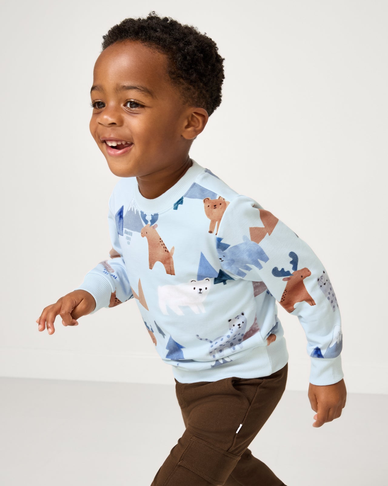 Child in motion wearing the Alpine Explorers Crewneck Sweatshirt