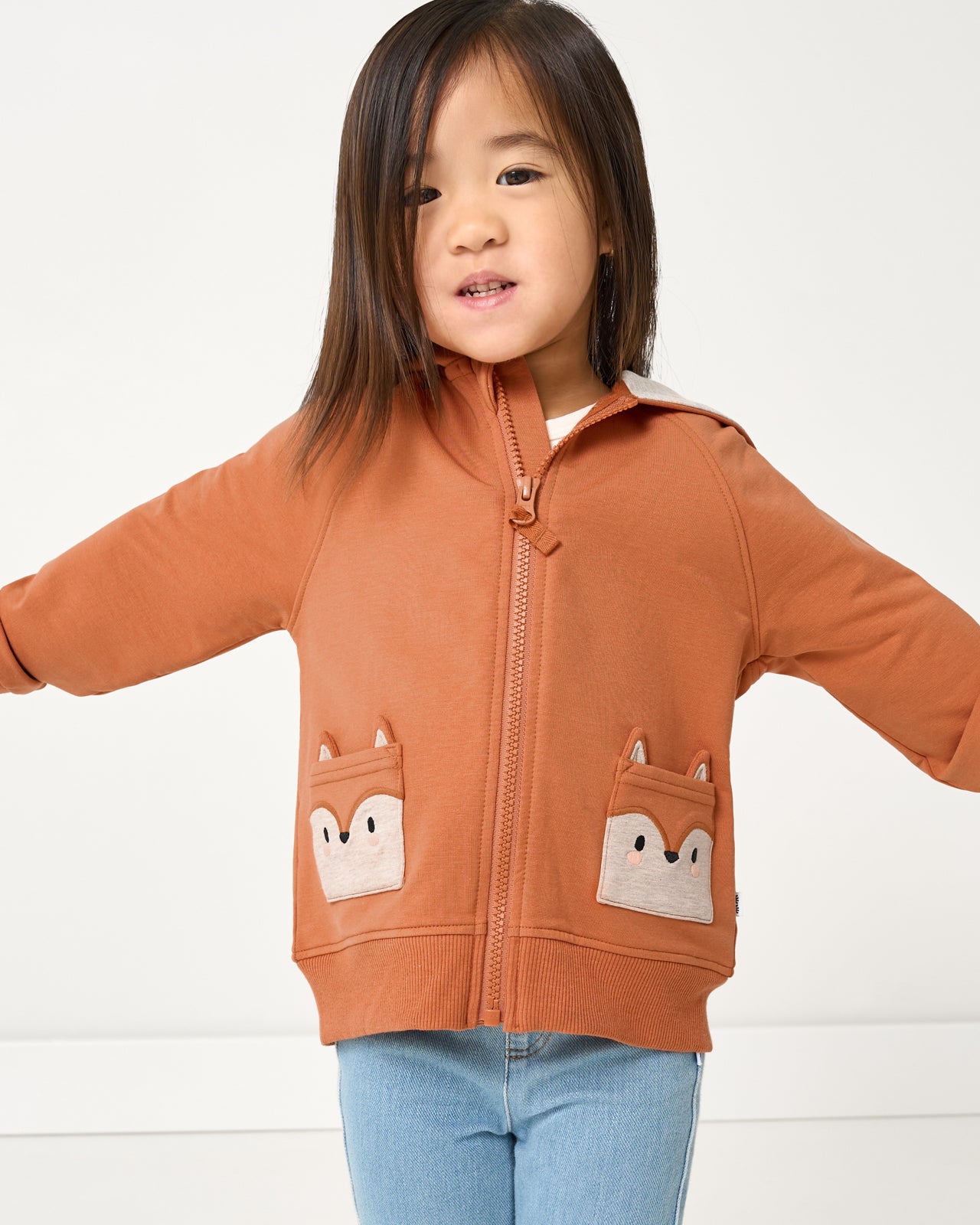 Girl wearing the Fox Zip Hoodie with denim pants