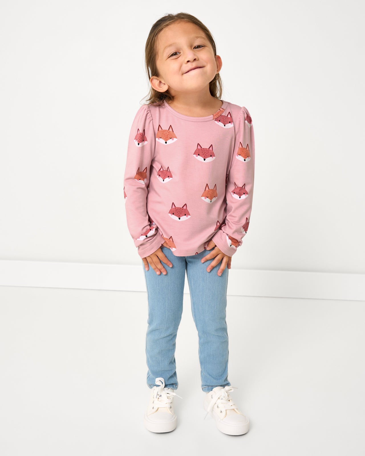 Girl wearing the Fox Tracks Puff Sleeve Tee with blue denim pants