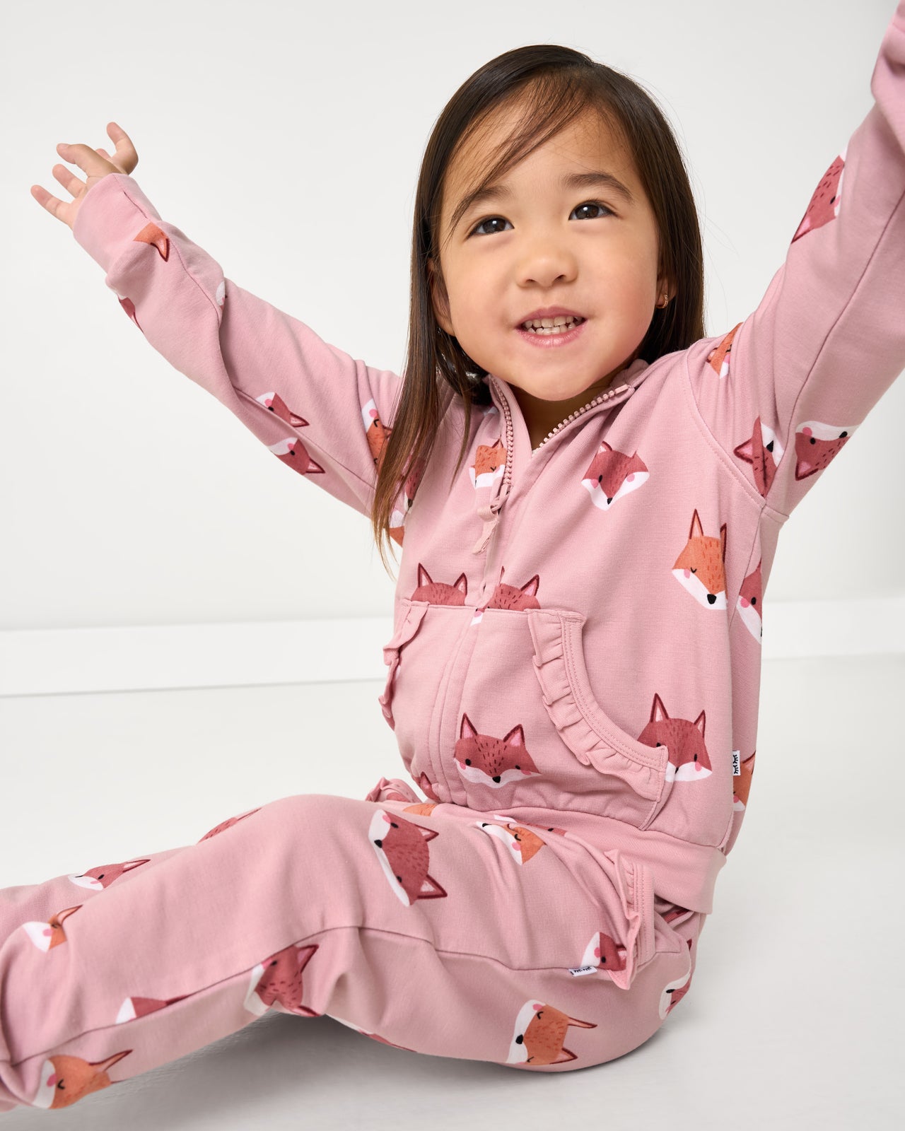 Posing child wearing the Fox Tracks Ruffle Zip Hoodie