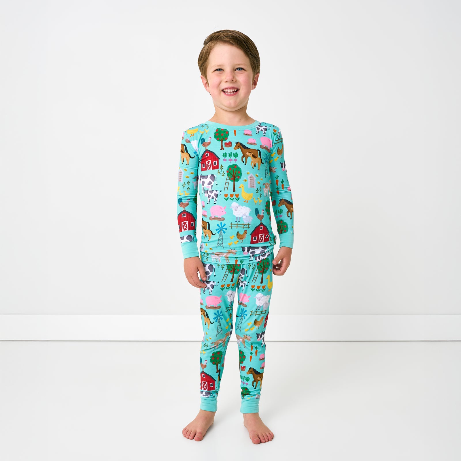 Standing child wearing the Turquoise Farm Fam Two-Piece Pajama Set
