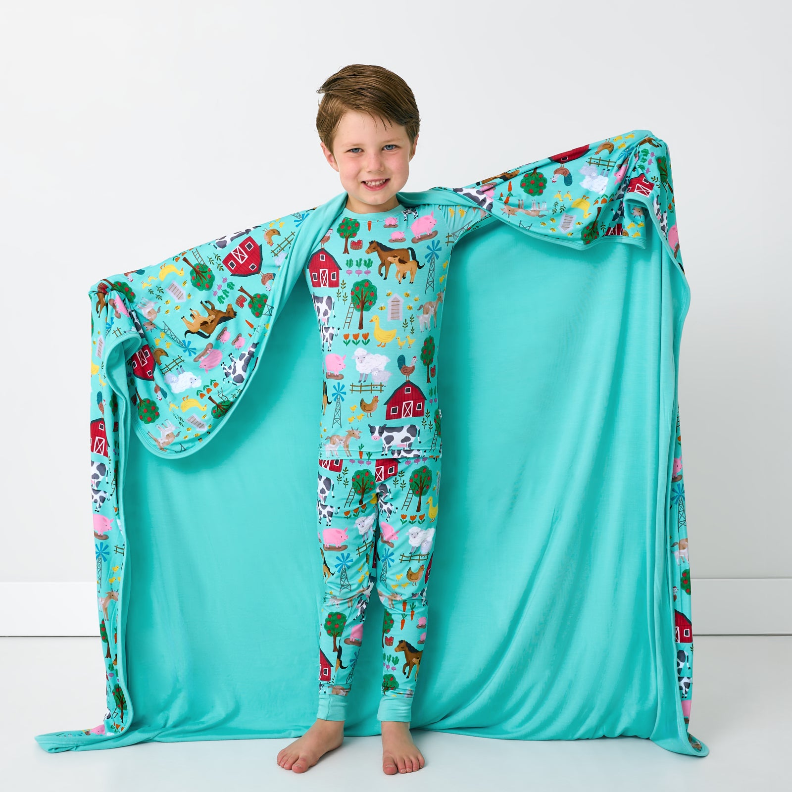 Standing child holding up the Turquoise Farm Fam Large Cloud Blanket® showing the solid side