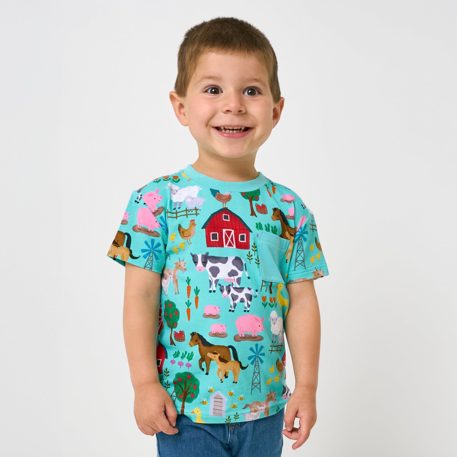 Standing child wearing the Turquoise Farm Fam Relaxed Pocket Tee
