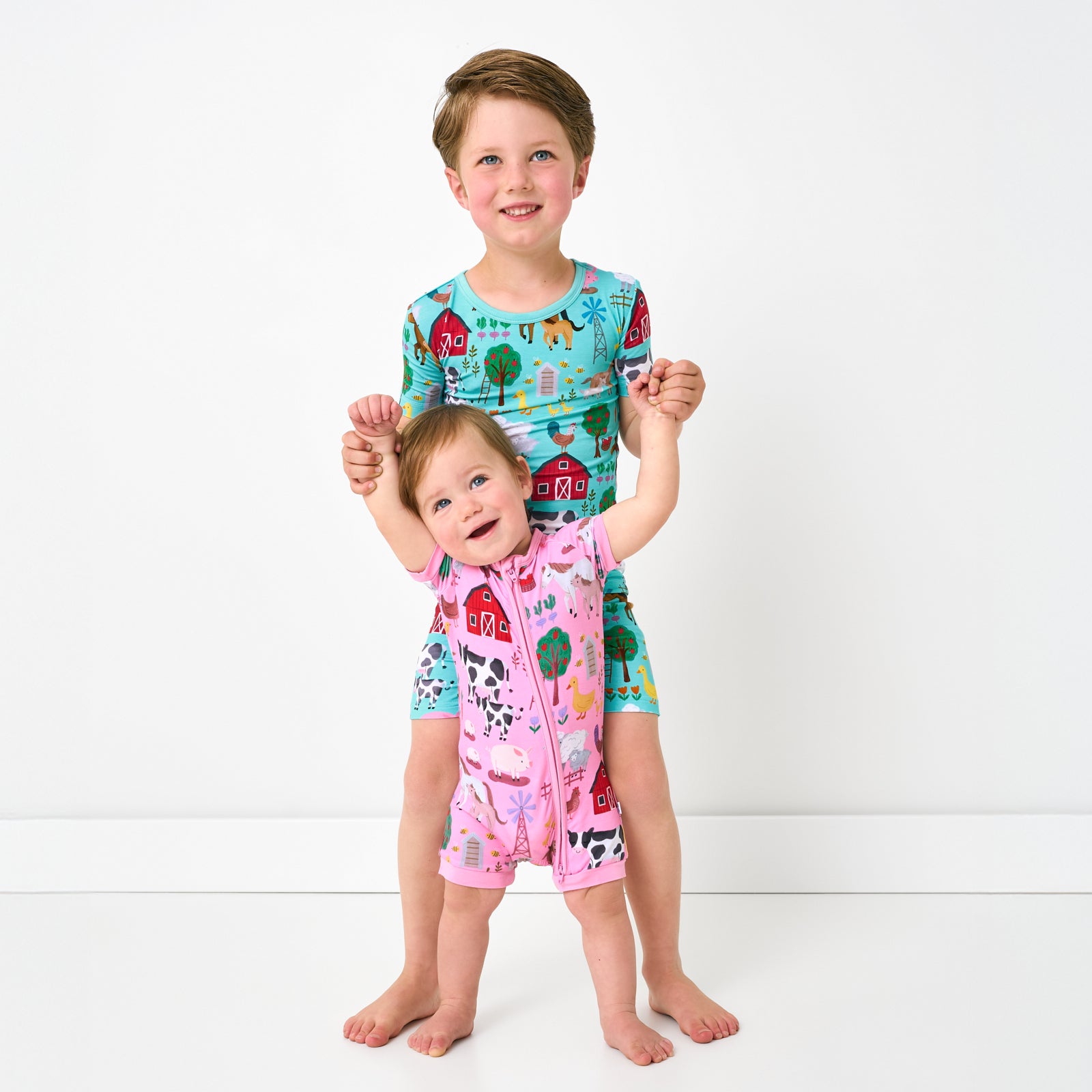 Two children wearing Farm Fam bamboo pajamas for sibling matching