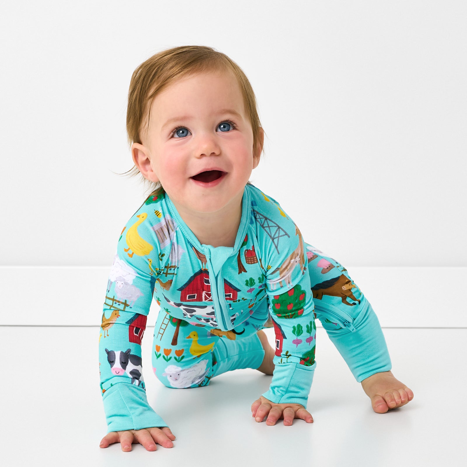 Crawling baby wearing the Turquoise Farm Fam Zippy