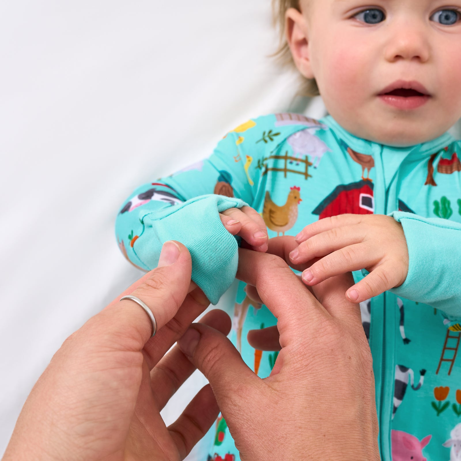 Adult demonstrating the hand fold over feature on the Turquoise Farm Fam Zipper pajamas